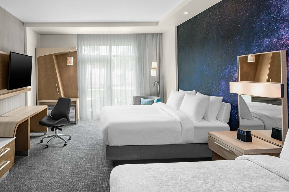 Guest room with galaxy wall mural and two queen beds at Courtyard by Marriott Titusville Kennedy Space Center