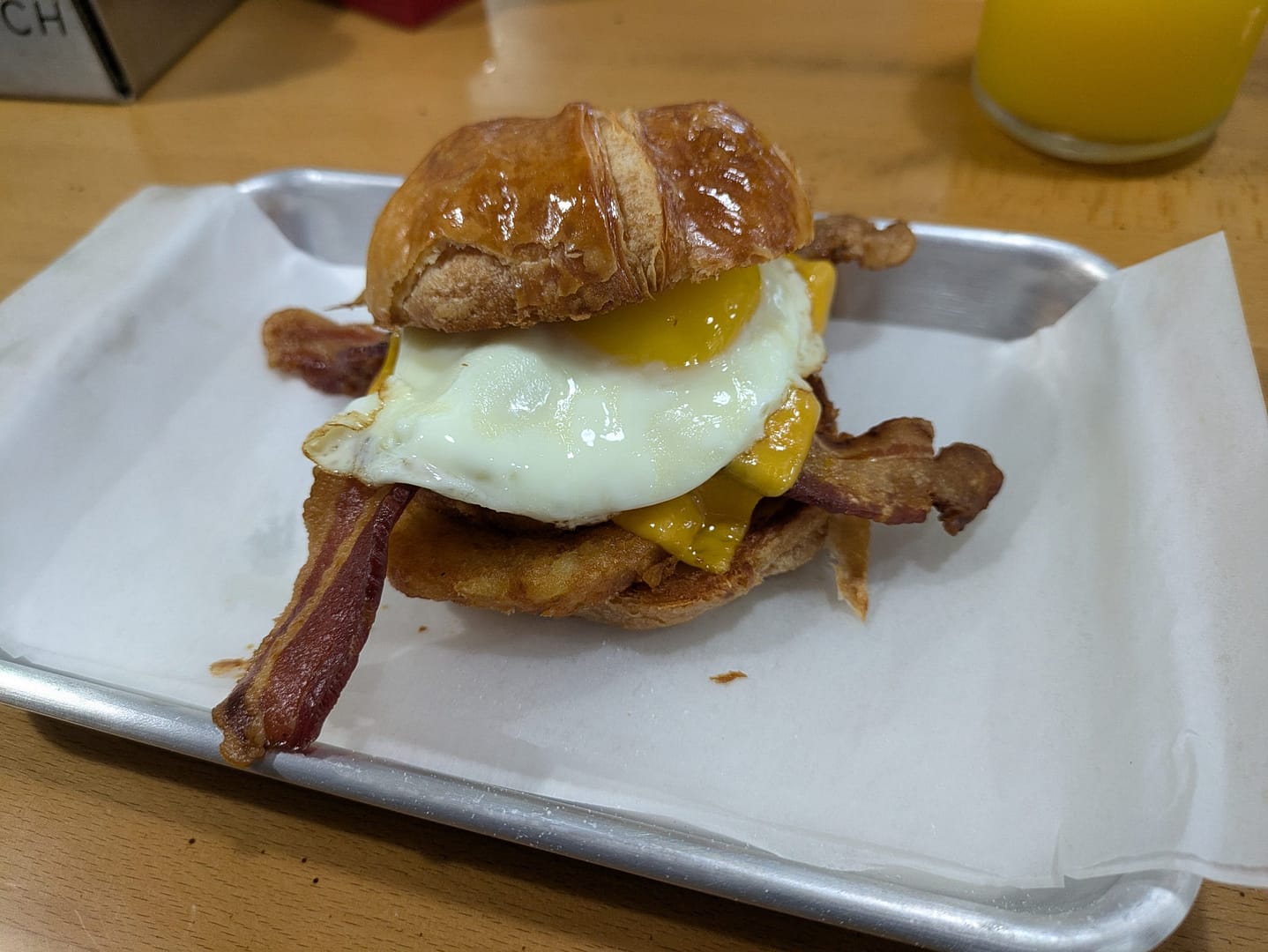 Bacon Bitch breakfast sandwich with egg, bacon, and hashbrown on a croissant