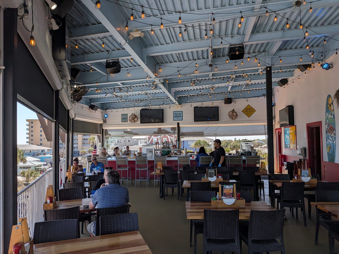 Open-air upstairs dining at Crabby's Bar and Grill with ocean views