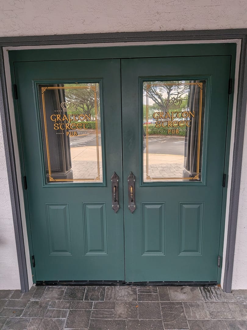 Green double doors with gold lettering at Grafton Street Pub Lake Mary